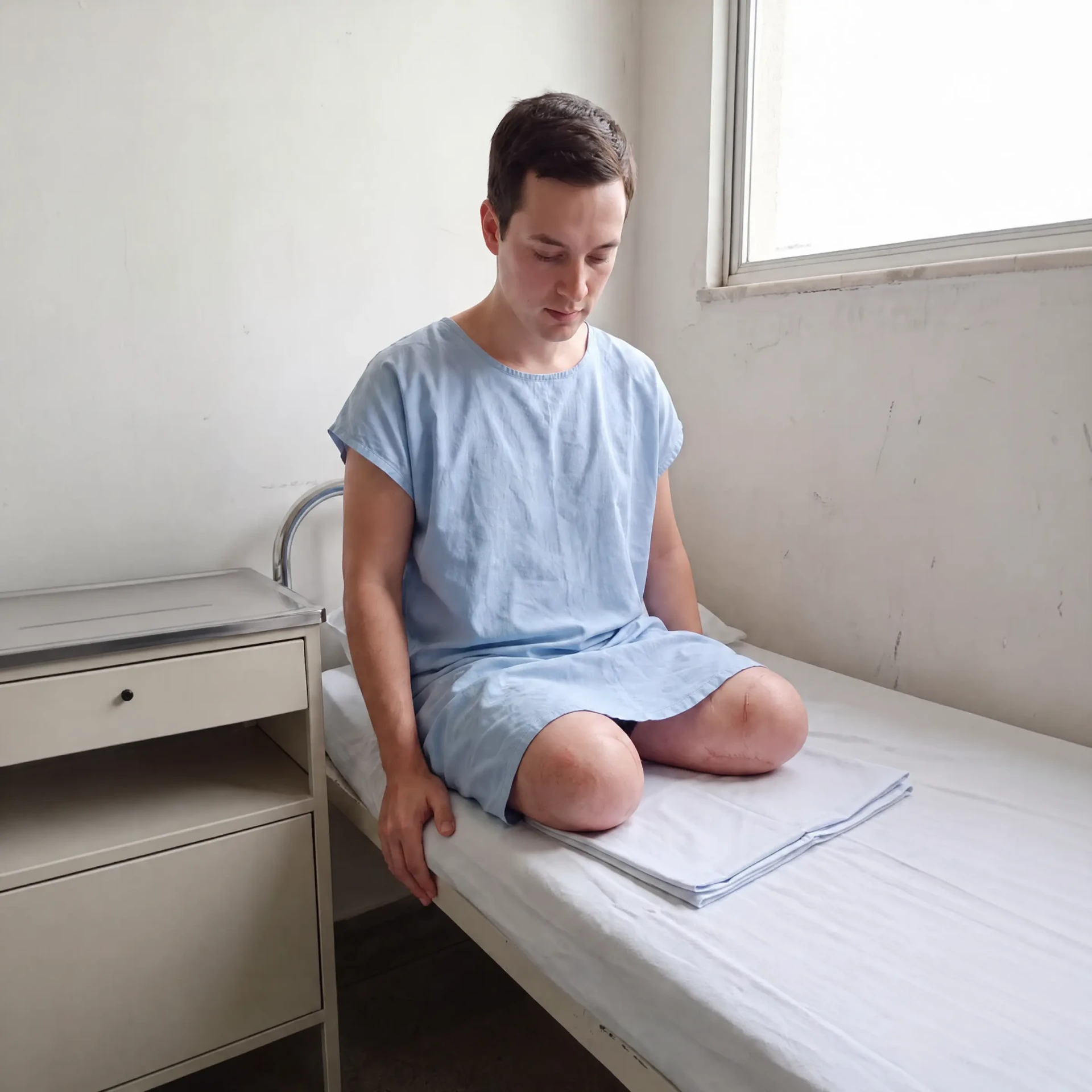 Padre Mateus sentado na cama do hospital